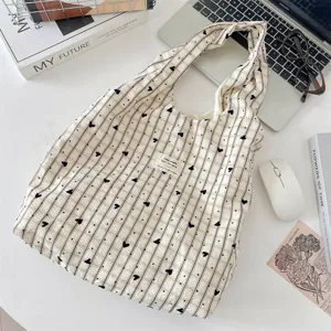 Casual τσάντα tote από καμβά με κάθετες ρίγες και μαύρο τύπωμα καρδιάς για καθημερινή χρήση.