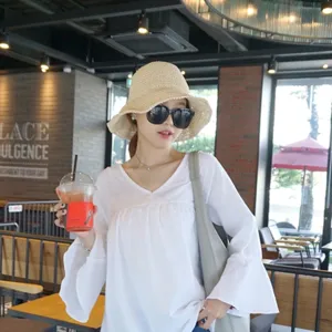 Vue détaillée du chapeau de soleil en paille tissée élégant dans un café naturel.