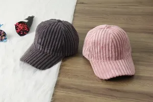 Detail view of winter corduroy baseball caps in dark grey and pink, soft warm duck tongue hats.