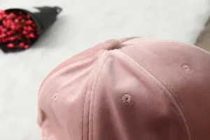 Gros plan sur le haut de la casquette en velours rose, tissu doux, accessoire.