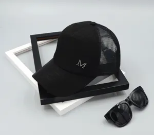 Detailed view of a black summer mesh baseball cap with a stylish metal letter M decoration.