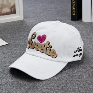 White baseball cap with glittery Sweetie embroidery and pink heart detail for daily wear.