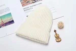 White winter knitted beanie hat detail showing cozy ribbed texture, perfect warm headwear.