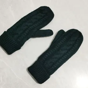 Detail view of thick cable knit winter warm mittens, cozy fleece lined design for women.