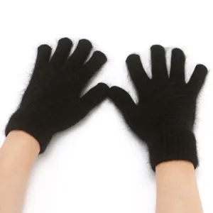 Close-up detail of black fuzzy knit five-finger gloves showing soft texture and cozy wrist.