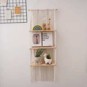 Bohemian handmade woven cotton rope wall hanging shelf with three wooden tier display.