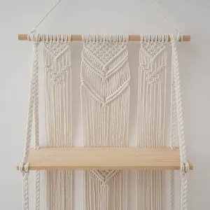 Bohemian handmade macrame wall hanging shelf with wooden plank for bedroom decor detail.