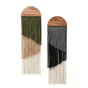 Close-up details of bohemian multi-layer tassel wall hanging with a wooden semi-circle top.
