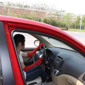 Detailed view of woman wearing red lace driving sun protection sleeves inside a car.