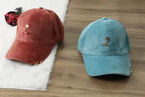 Detailed view of fashionable velvet baseball caps for men and women, featuring metal ring accents.