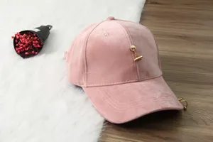 Close-up detail of the pink velvet baseball cap featuring a chic metal ring and chain accessory.