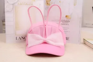 Vue détaillée de la casquette de baseball rose mignonne avec oreilles de lapin et nœud blanc.