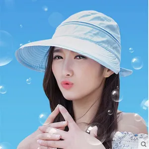 Close-up detail of a light blue sun protection hat worn by a model, showing brim and fabric.