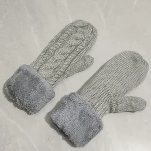 Detailed view of grey winter knitted mittens featuring cozy plush cuffs and cable knit texture.