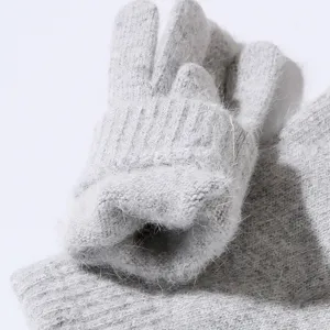 Close up view of cozy light gray fuzzy knit gloves showing soft texture and thick material.