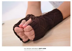 Close-up detail of winter warm brown knitted fingerless gloves with cable grid pattern.