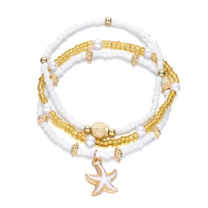 Close-up of summer beach beaded bracelet set with starfish and seashell charms, elegant details.