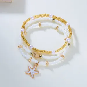 Multi-layer seed bead bracelet detailed close-up featuring starfish and seashell charms.