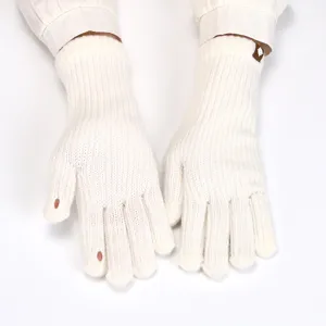 Close-up detail of soft white knitted fingerless gloves, winter warm design.