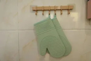 Silicone oven mitts hanging detail shot, heat-resistant baking gloves with anti-slip texture.
