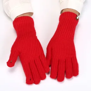 Close-up detail of red knitted fingerless winter gloves, showing warm texture and design.