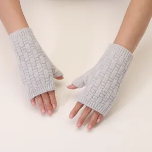 Close-up view of cozy light gray knit half-finger gloves featuring a stylish jacquard texture.