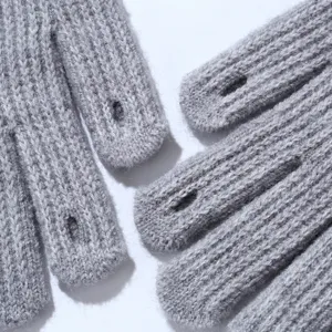 Close-up van grijze gebreide touchscreen handschoenen met openingen voor telefoongebruik.