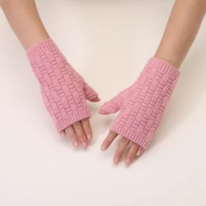 Detail view of pink knitted fingerless gloves showing delicate jacquard texture and warm wear.