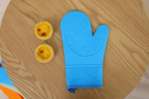 Close-up detail of blue silicone oven mitt with anti-slip pattern for safe baking and cooking.