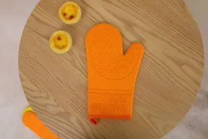 Orange silicone heat resistant baking oven mitt close up detail with textured grip