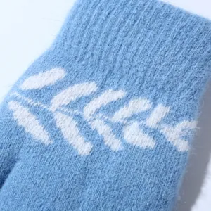Detailed view of women winter warm fluffy plush mittens in light blue with white knit pattern.