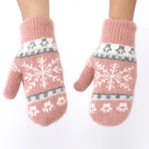 Close up detail of pink plush winter mittens with cute snowflake knit pattern warm cozy wear.