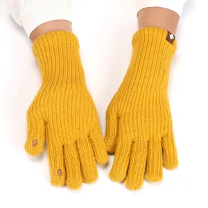 Yellow knitted fingerless gloves detail, cozy winter wool hand warmers with cute label.