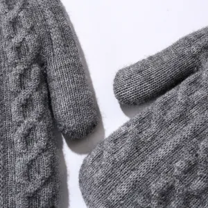 Primo piano dettagliato di guanti di maglia grigi, che mostra la struttura e il tessuto caldo.