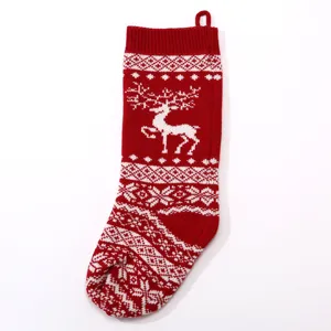 Detailed view of the red knit Christmas stocking featuring a festive white reindeer and snowflake pattern.