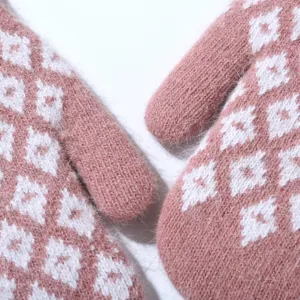 Close-up of pink knitted winter mittens with white jacquard pattern, thick cozy fleece lined.