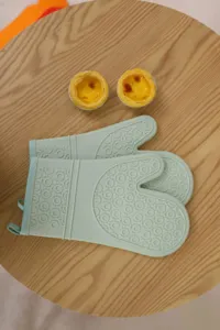 Silicone heat resistant oven mitts with textured non-slip grip for baking kitchen cooking.