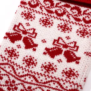 Detailed view of red and white knitted Christmas stocking with festive jacquard pattern.