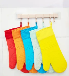 Detailansicht bunter Silikon-Ofenhandschuhe hängend an Haken mit hitzebeständiger Textur.