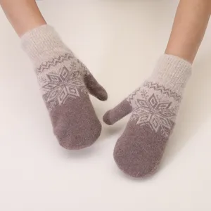 Close-up detail of cozy winter knit mittens with soft rabbit hair and classic snowflake pattern.