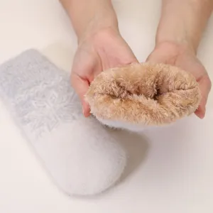Thickened fleece-lined knitted mittens with winter snowflake jacquard pattern for warmth.