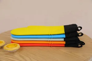 Nahaufnahme gestapelter, mehrfarbiger Silikon-Hitzeschutz-Ofenhandschuhe zum Backen.