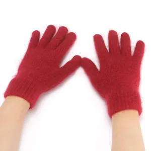 Detailed shot of soft red fuzzy knitted gloves showing fine wool texture and warm cuff.