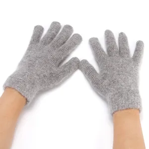 Detailed view of grey fuzzy knit gloves showing soft winter warm woolen texture and fingers.