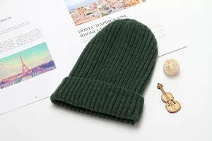 Detail view of dark green ribbed knitted beanie hat, soft wool material for winter warmth.