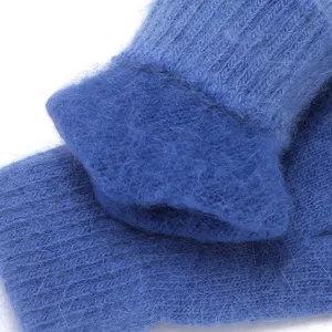 Blue fuzzy knit gloves detail close up showing soft warm winter texture wool fabric soft cozy fit