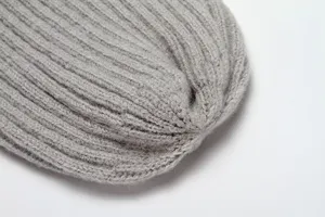Close-up view of soft grey ribbed knit beanie texture, showing cozy warm winter hat fabric.