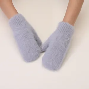 Close-up detail of fluffy knitted winter mittens in soft light grey, warm and thick.