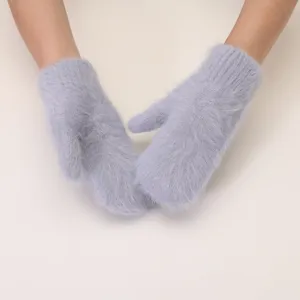 Close up of soft fuzzy winter mittens in light blue, warm and cozy knit texture detail.