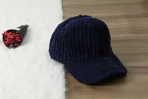 Detailed shot of the navy blue corduroy baseball cap showing soft ribbed texture fabric.